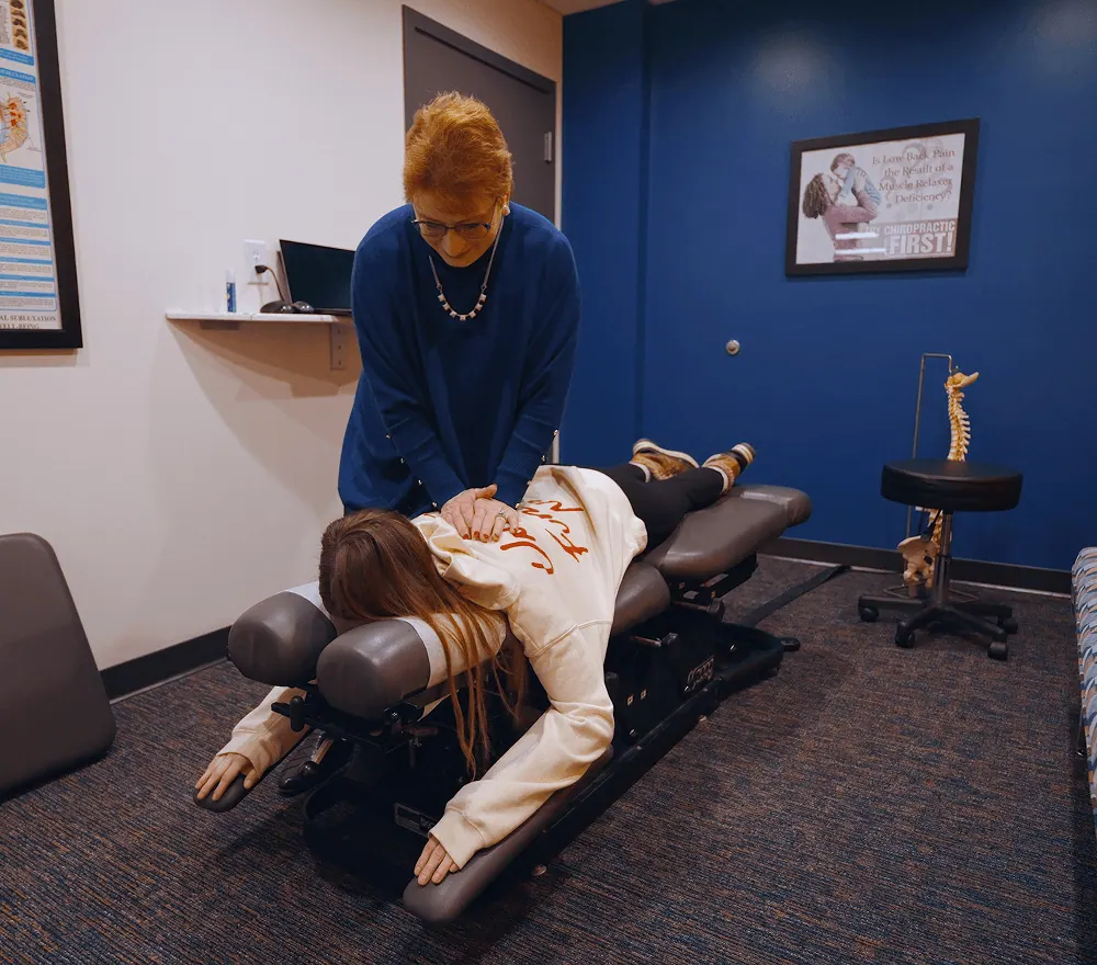 Dr. Trish Wolff adjusting a patient lying on the chiropractic table