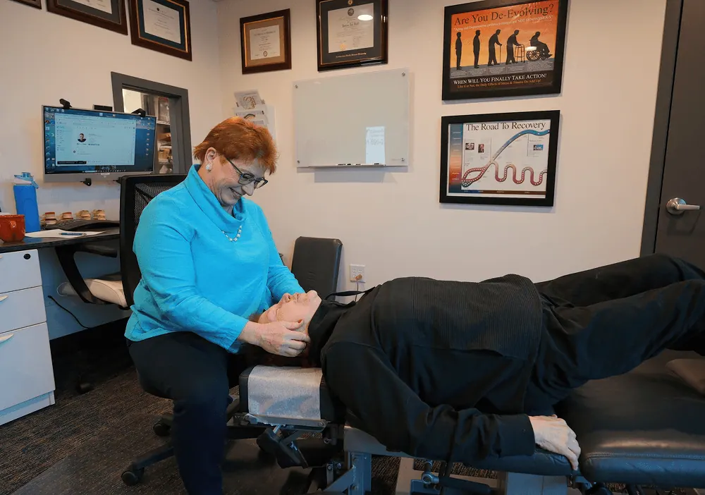 Dr. Trish Wolff treating a patient's neck on the table